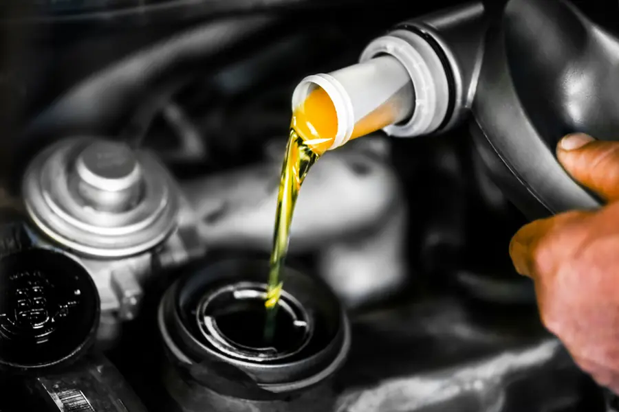 Oil being poured into a vehicle's engine during a service.