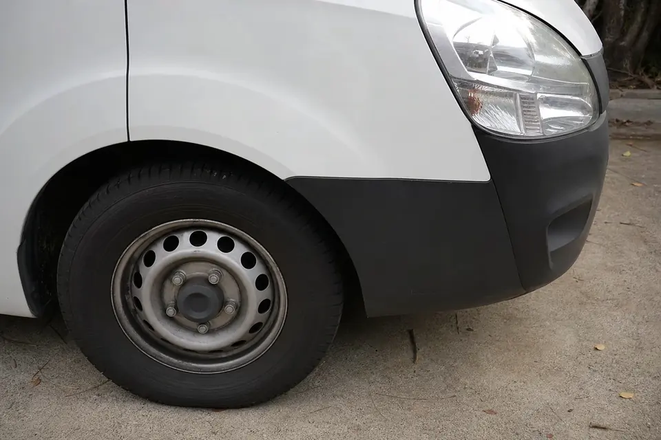 Front wheel and body panel of a white commercial van