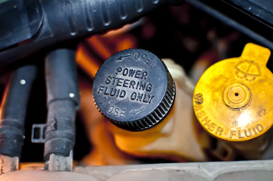 Power steering fluid reservoir caps labelled "Power Steering Fluid Only" in an engine bay.