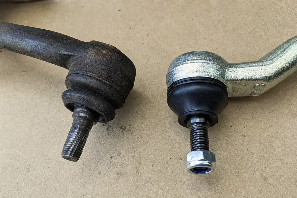 Used and new steering tie rod ends side by side