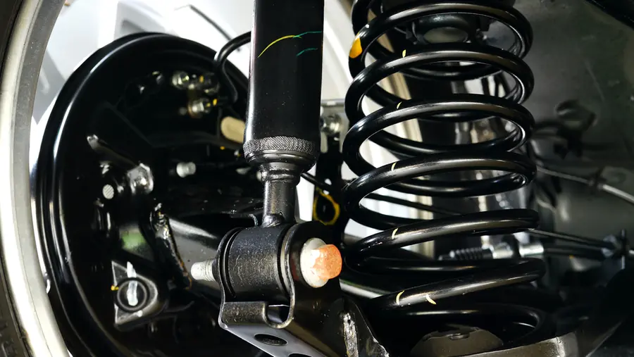 Close-up of a coil spring and shock absorber assembly on a vehicle's suspension.